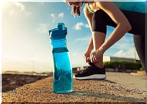 Sportswoman training with a bottle of water