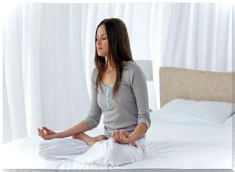 Woman meditating in the bedroom