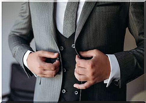 Groom testing the buttons on his suit